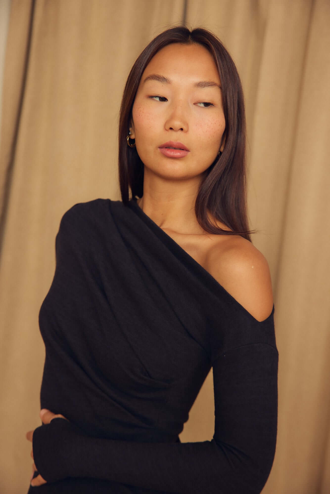 Model wearing the Black Wool Drape Midi Dress featuring an elegant draped neckline and fluid silhouette.