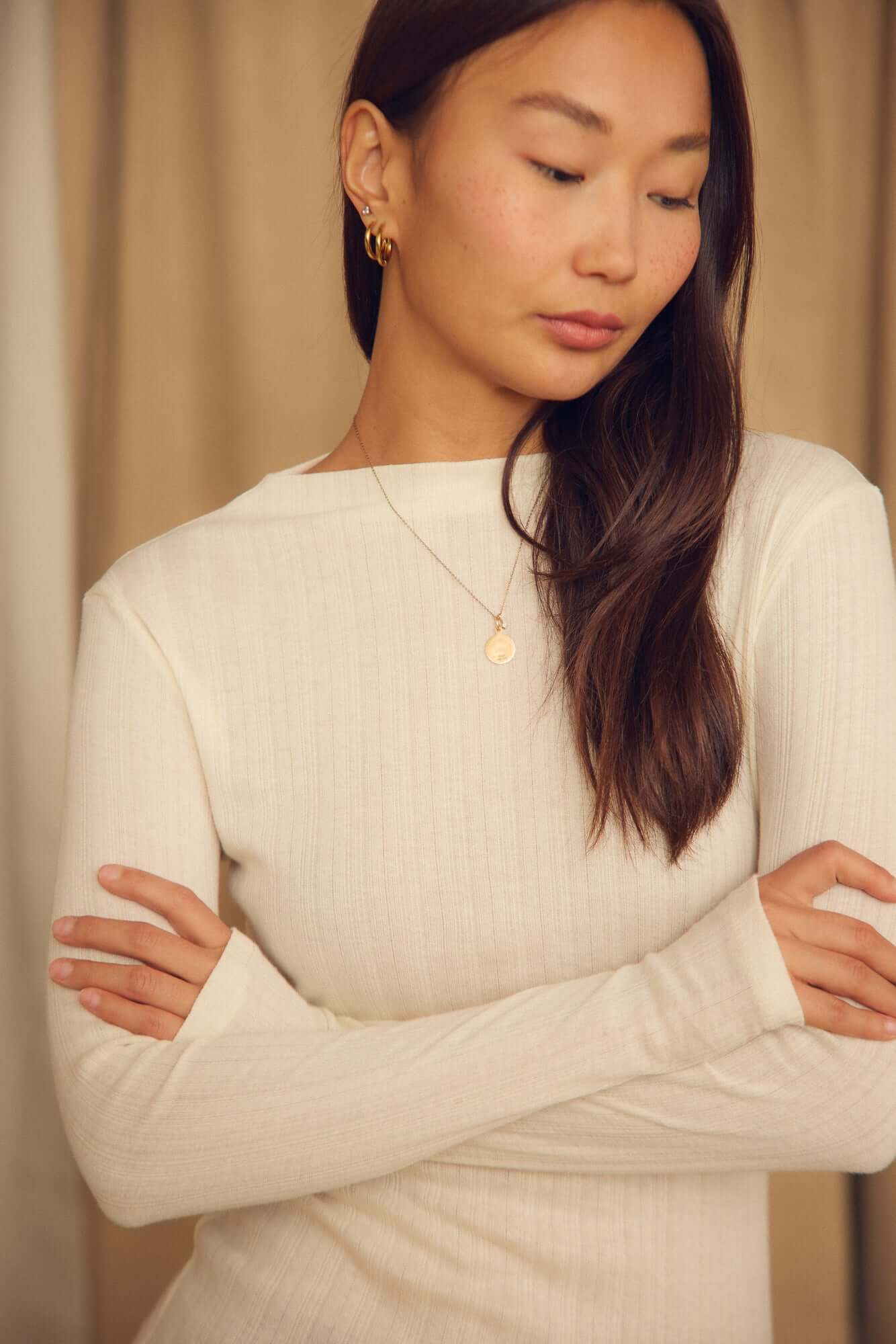 Ecru Lyocell Ribbed Long Sleeve Top worn by a woman with light brown hair, featuring a soft close-to-body fit.