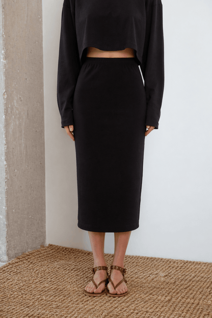 Organic Cotton Midi Skirt in Black worn with a matching black crop top and sandals, perfect for stylish spring-summer looks.