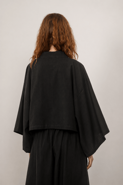 Back view of the Organic Cotton Kimono Jacket in Black, showcasing its relaxed silhouette and oversized design.