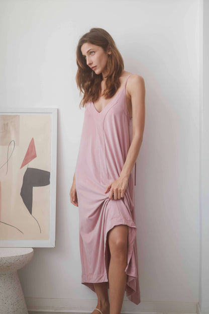 Model wearing a ROSE CUPRO MIDI DRESS in blush, showcasing adjustable straps and elegant midi length.