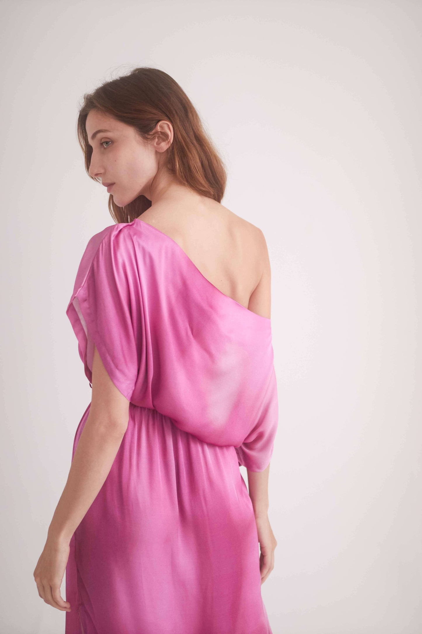 Model wearing a pink off-shoulder midi dress made from 100% Ecovero viscose, showcasing side splits and a stylish design.