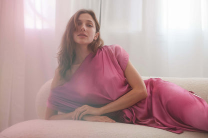 Model wearing pink off-shoulder drape dress, showcasing its elegant design and soft fabric.