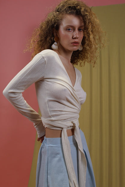 Model wearing Banana Pineapple Multiway Wrap Top in Ecru with stylish wrap design and thumb hole detailing.