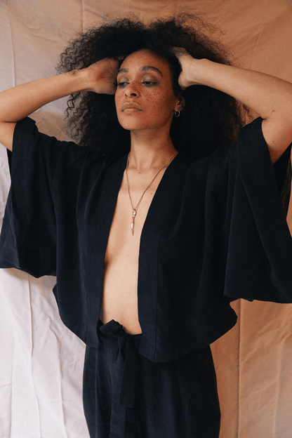 Model wearing an Organic Cotton Kimono Jacket in Black, showcasing its relaxed silhouette and oversized design.