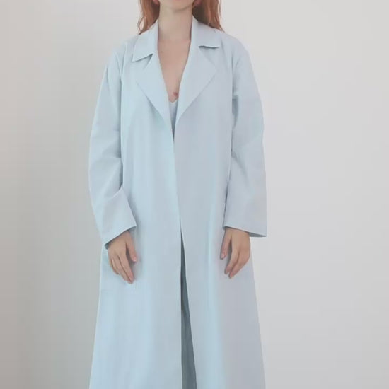Model wearing the Organic Cotton Wide Jumpsuit in Pale Blue, styled with a light oversized coat.
